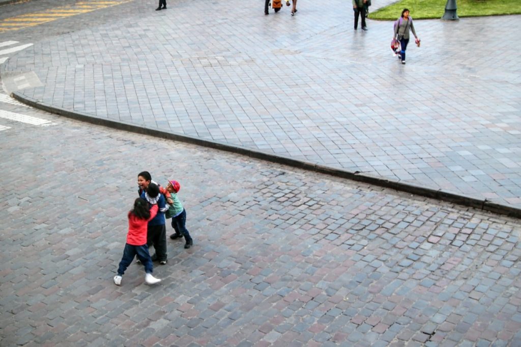 Kids play fighting in the plaza